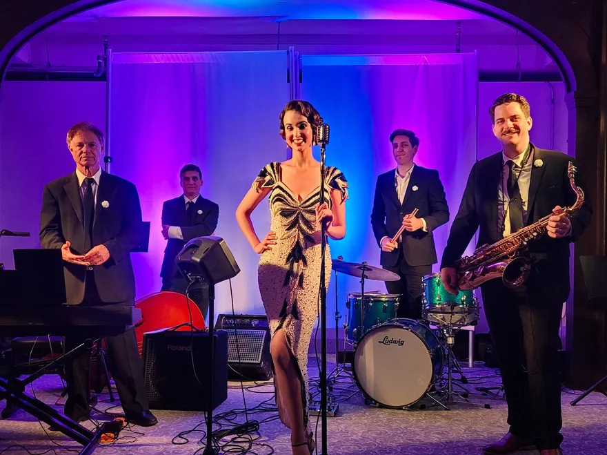 Ashley Anne in a beaded 1920s gown on the purple-lit stage of The Charleston in Orange County