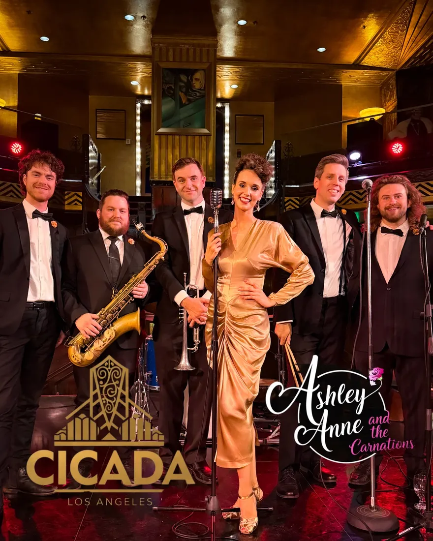 Ashley Anne in a gold satin gown with The Carnations in black tie on the Art Deco stage of the Cicada Club in Los Angeles